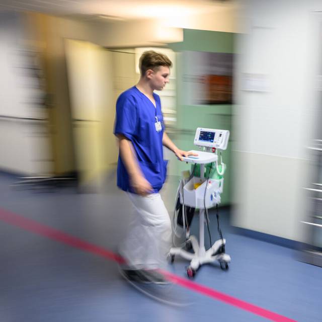 Ein Krankenhaus-Mitarbeiter beziehungsweise Pfleger ist im Krankenhaus zu sehen.