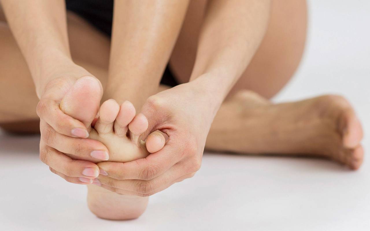 Eine Frau massiert ihre Zehen
