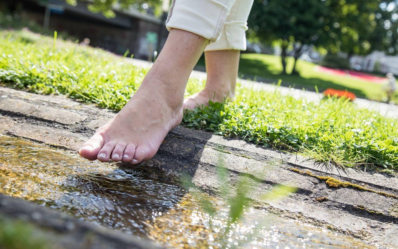 Eine Person läuft barfuß auf dem Rasen