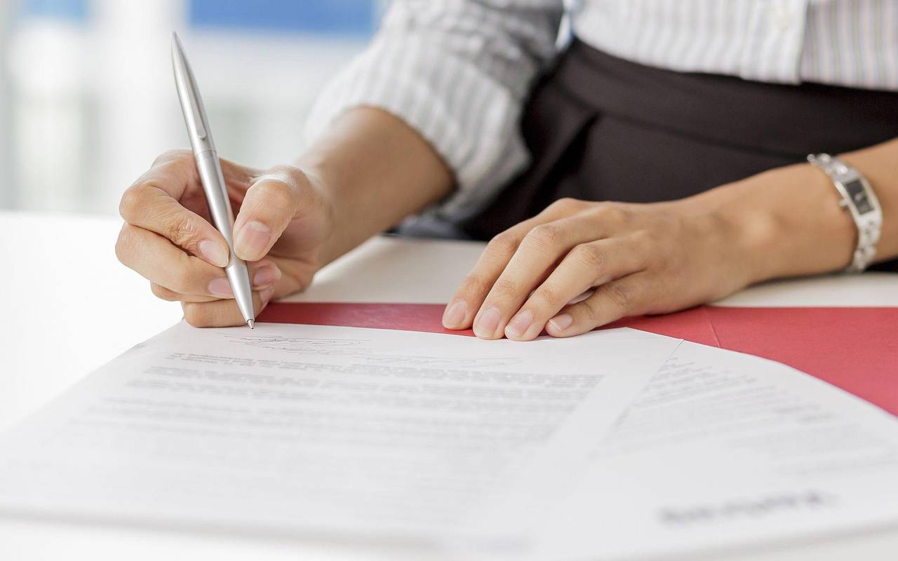 Frau unterschreibt ein Arbeitszeugnis