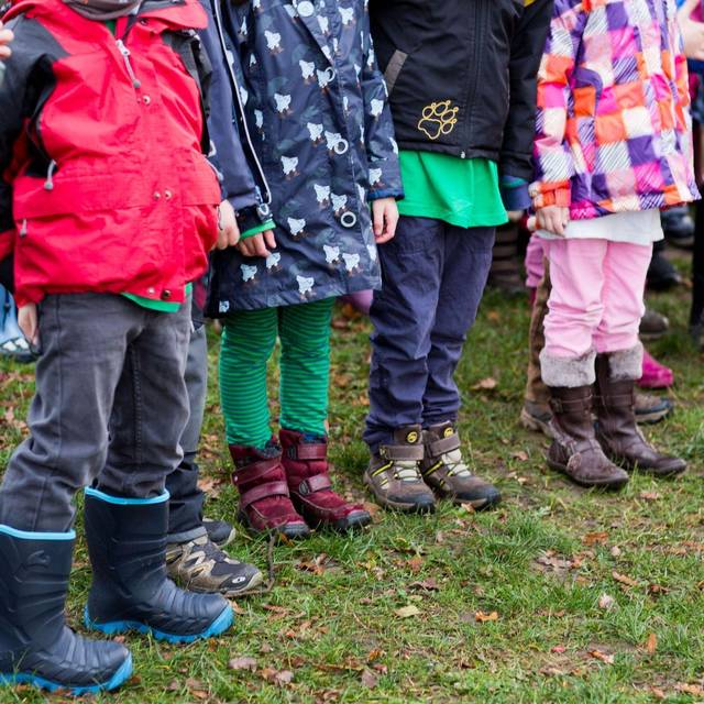 Kinder stehen in einem Garten