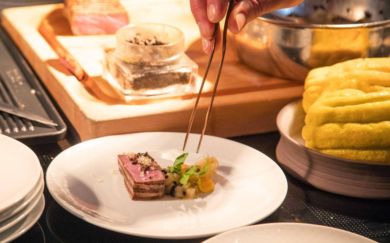 Ein Koch richtet sein Gericht auf einem Teller an