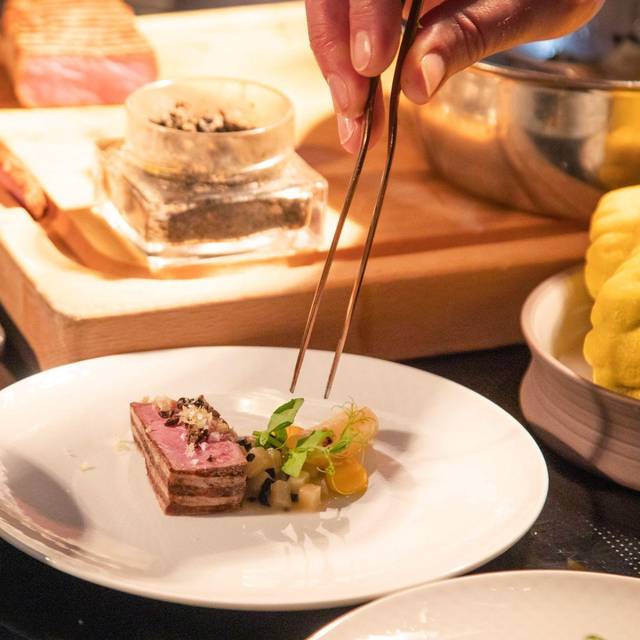 Ein Koch richtet sein Gericht auf einem Teller an