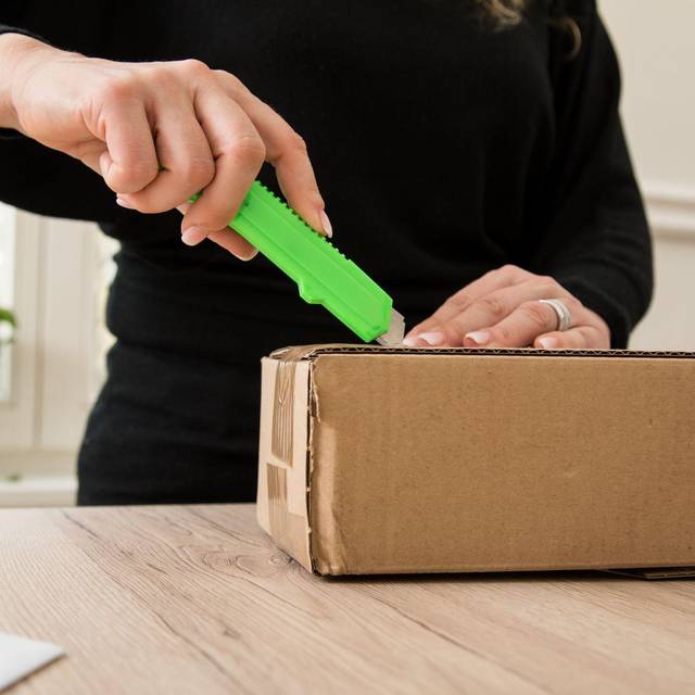 Frau öffnet ein Paket