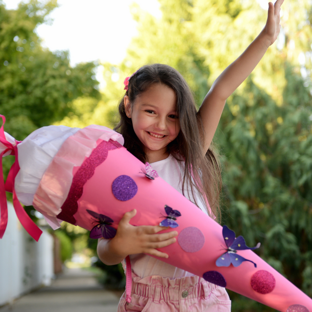 Glückliches Mädchen mit pinker Schultüte