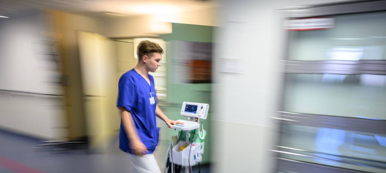 Ein Krankenhaus-Mitarbeiter beziehungsweise Pfleger ist im Krankenhaus zu sehen.