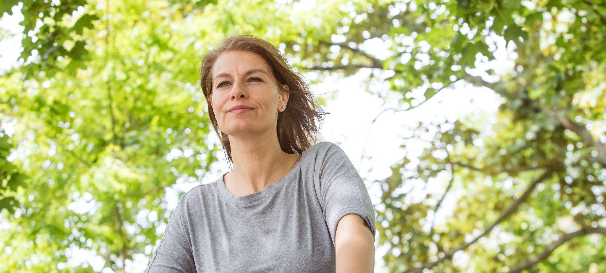 Frau fährt mit Fahrrad durch einen Park