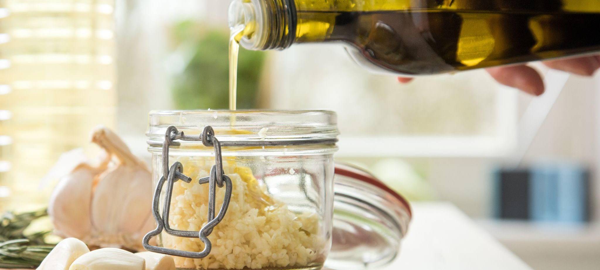 Olivenöl wird in ein Einmachglas geschüttet