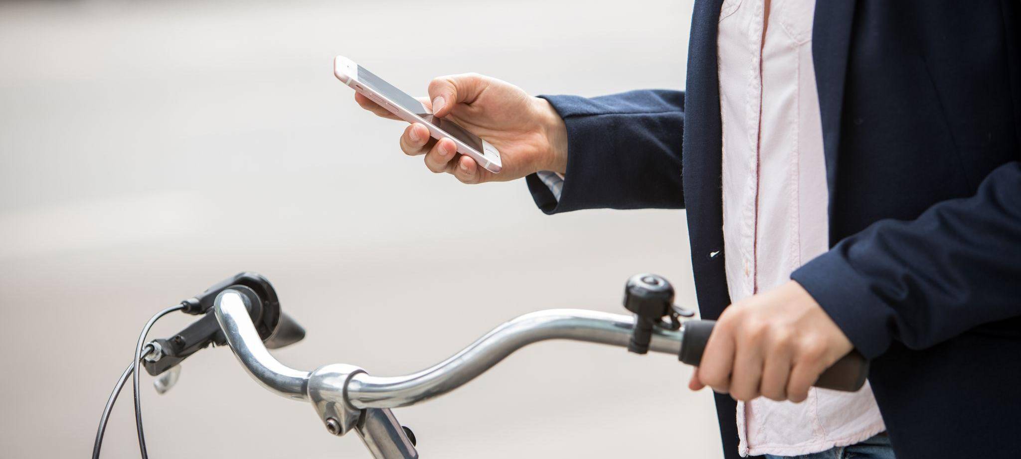 Eine Frau mit Smartphone und Fahrrad