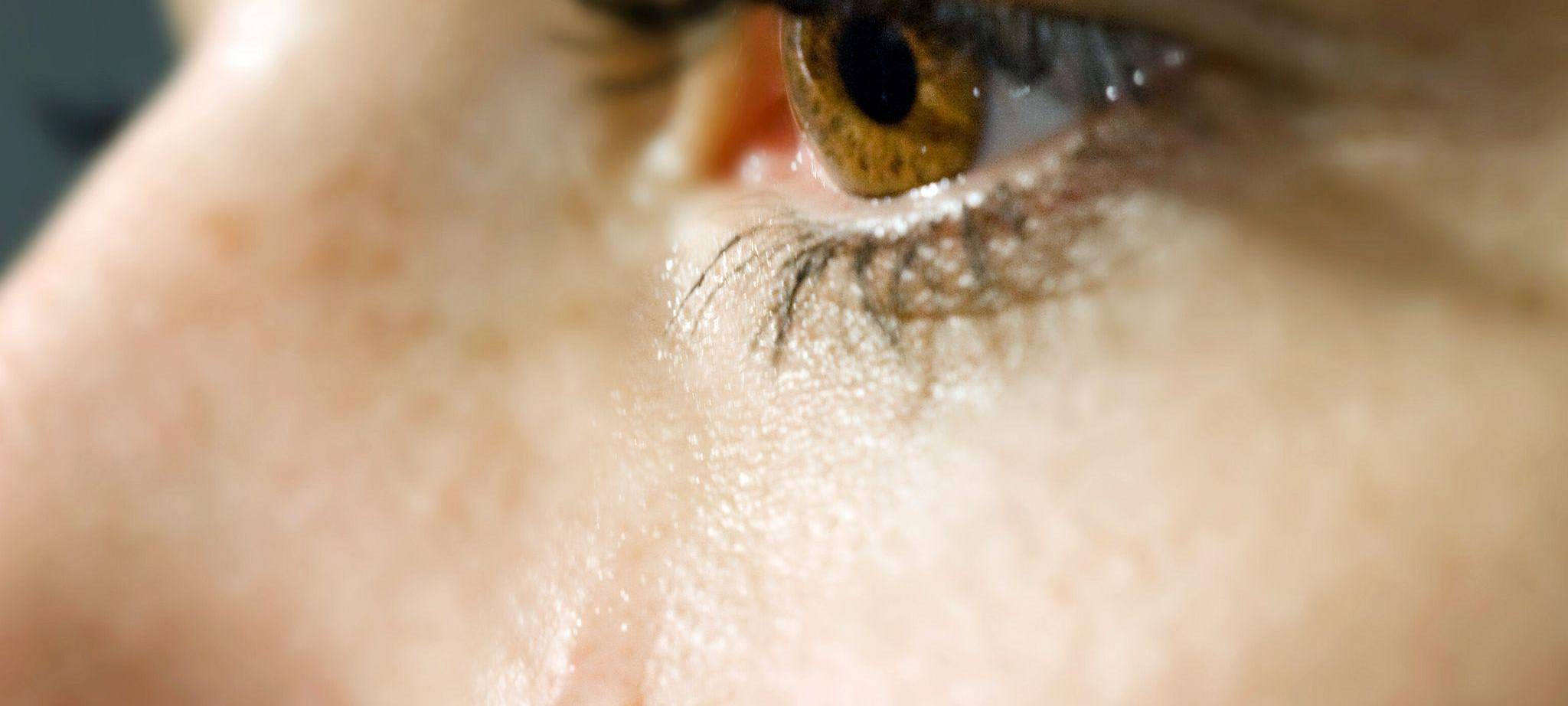 Träne rollt über die Wange einer Frau