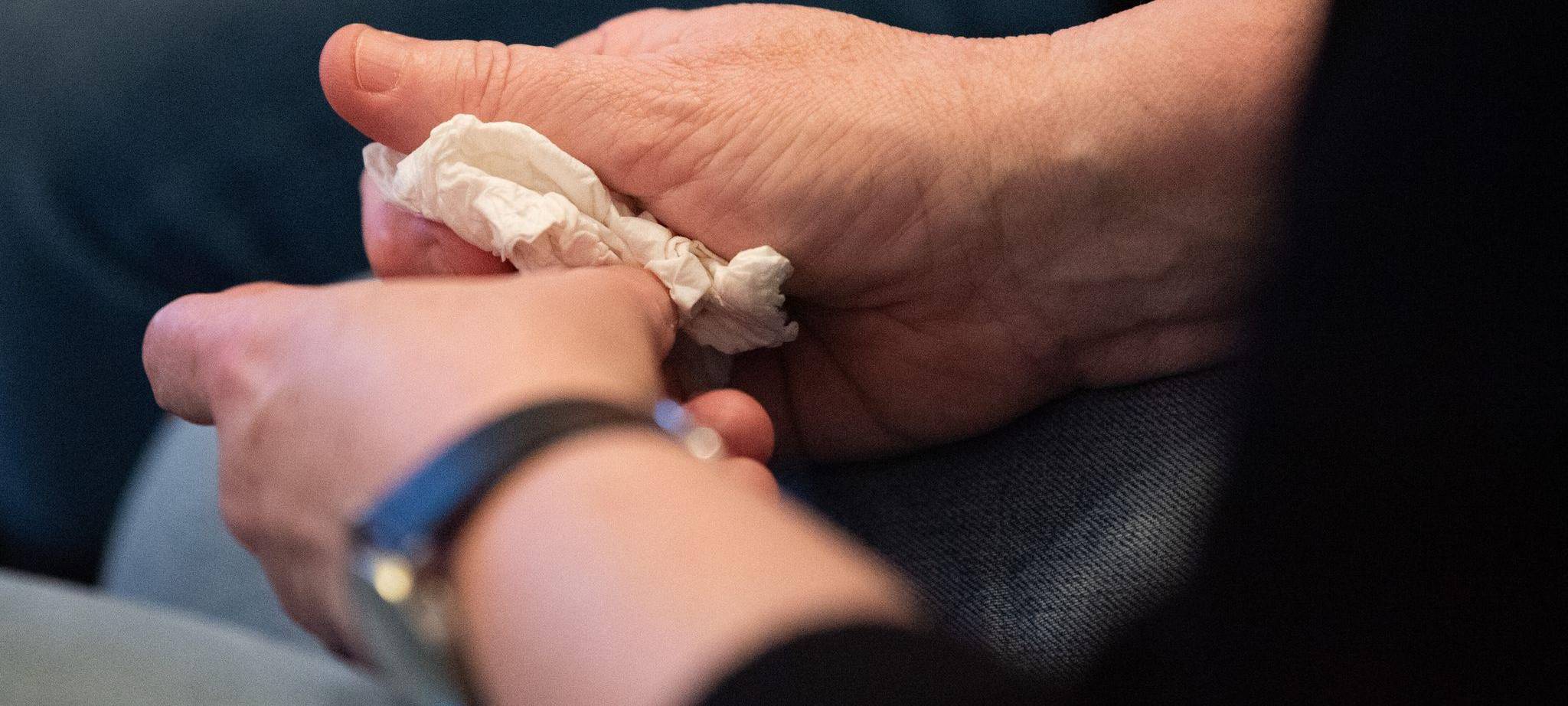 Person hält ein Taschentuch in den Händen