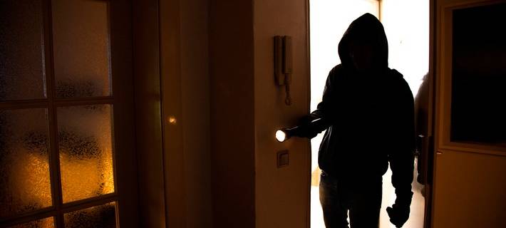 Symbolbild: Ein Einbrecher dringt in ein Haus ein.