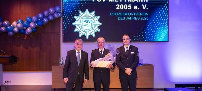 Innenminister Herbert Reul und Polizeidirektor Markus Henkel vom LAFP überreichten Polizeihauptkommissar Peter Creutz die Auszeichnung für den PSV Mettmann als Polizeisportverein des Jahres.