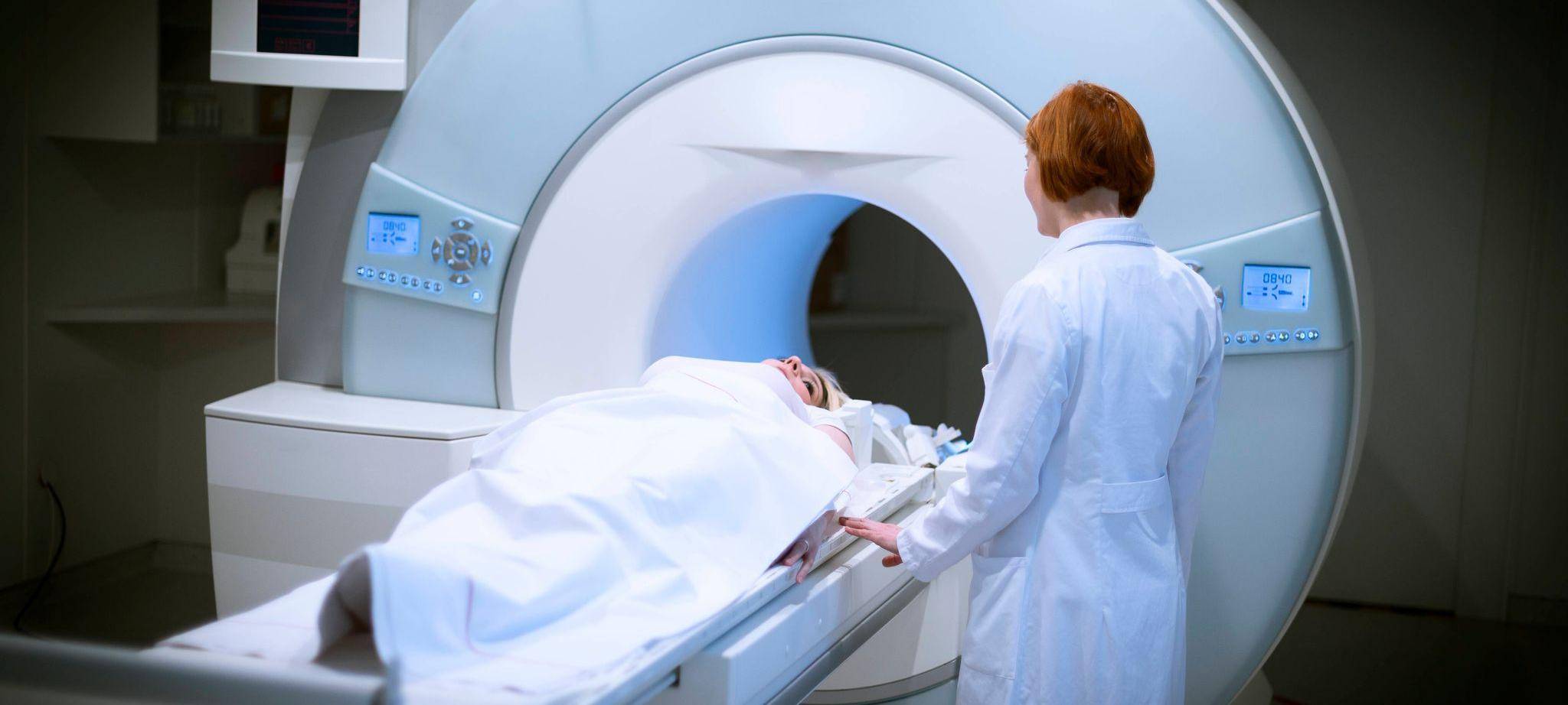 Ärztin bereitet eine Patientin für ein MRT vor
