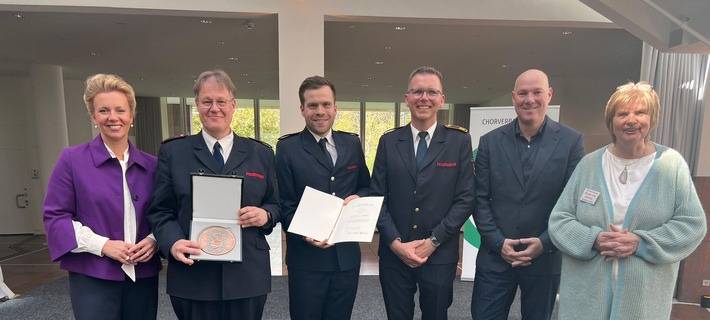 Die Auszeichnung wurde durch Ina Brandes, Ministerin für Kultur und Wissenschaft des Landes Nordrhein Westfalen, sowie Regina van Dinther, Präsidentin des Chorverbands NRW e.V., überreicht. Für den Musikzug nahmen Musikzugführer (kom.) Karsten Schenk und sein Stellvertreter Markus Kipphardt an der Feierstunde teil. Begleitet wurden sie von dem Bürgermeister der Stadt Velbert, Dirk Lukrafka sowie Manuel Schoch, dem Leiter der Feuerwehr Velbert.